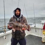 Keon Hatcher holding a fish in the water