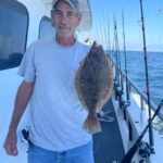 a man holding a fish on a boat