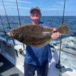 a man holding a fish on a boat