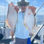 a man holding a fish on a boat