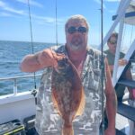 a man holding a fish on a boat