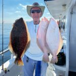 a man holding a fish on a boat