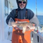 a man holding a fish on a boat