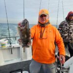 a man holding a fish on a boat