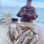 a man holding a fish in the water