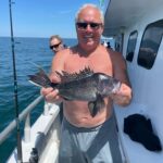 a person holding a fish on a boat