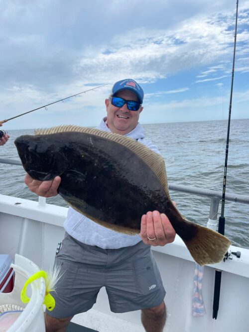 a person holding a fish on a boat