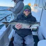 a man holding a fish on a boat