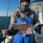 a man holding a fish on a boat