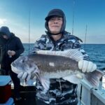 a man holding a fish on a boat