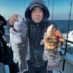 a person holding a fish on a boat posing for the camera