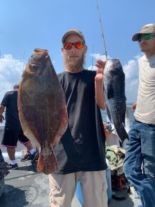 a group of people standing next to a person holding a fish