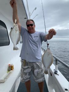 a man holding a fish on a boat