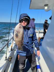 a man holding a fish on a boat