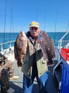 a man holding a fish on a boat