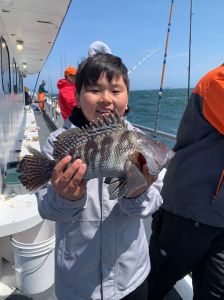 a young boy holding a fish