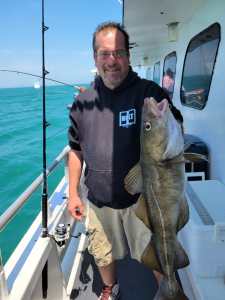 a man holding a fish on a boat