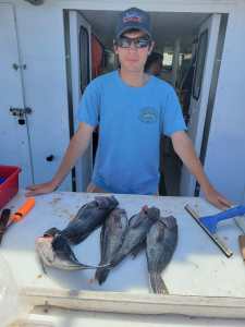 a man holding a fish on a cutting board