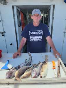 a man holding a fish on a cutting board