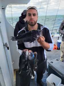 a person holding a fish on a boat