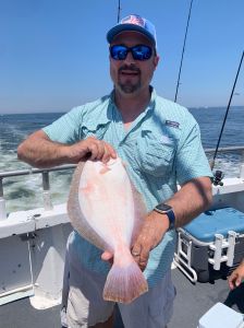 a man holding a fish on a boat