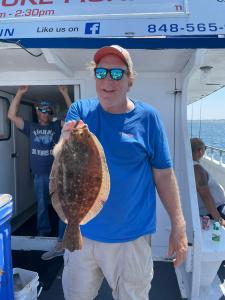 a person holding a fish on a boat posing for the camera