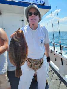 a man holding a fish on a boat