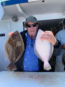 a person holding a fish posing for the camera