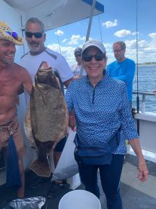 a group of people standing next to a person holding a fish