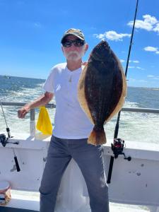 a man holding a fish on a boat in the water