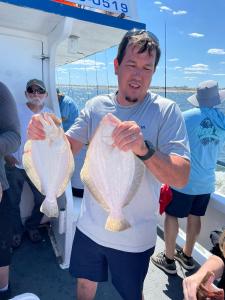 Steve Harwell et al. standing next to a person holding a fish