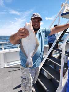 a person holding a fish on a boat