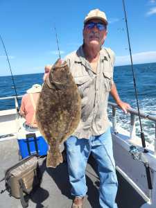 a man holding a fish on a boat