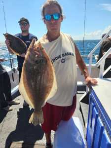 a man holding a fish on a boat