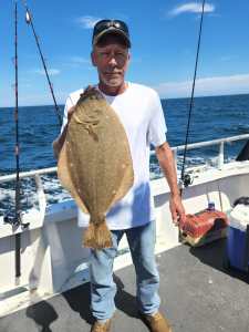 a man holding a fish on a boat