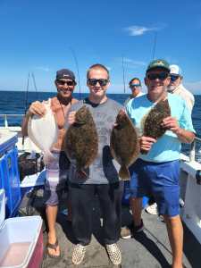 a group of people standing next to a person holding a fish