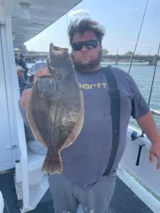 a man holding a fish on a boat