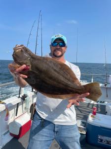 a man holding a fish on a boat