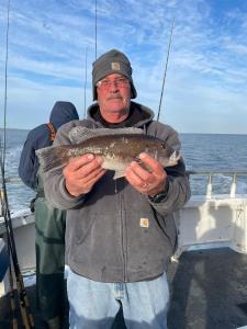 a man holding a fish on a boat