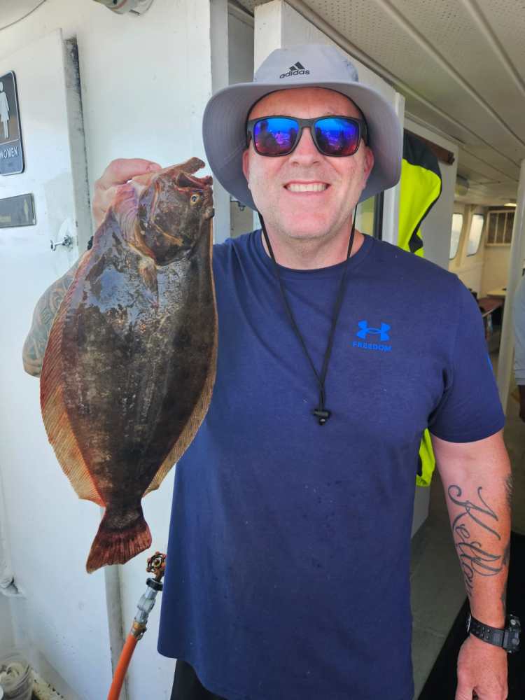 a man holding a fish posing for the camera