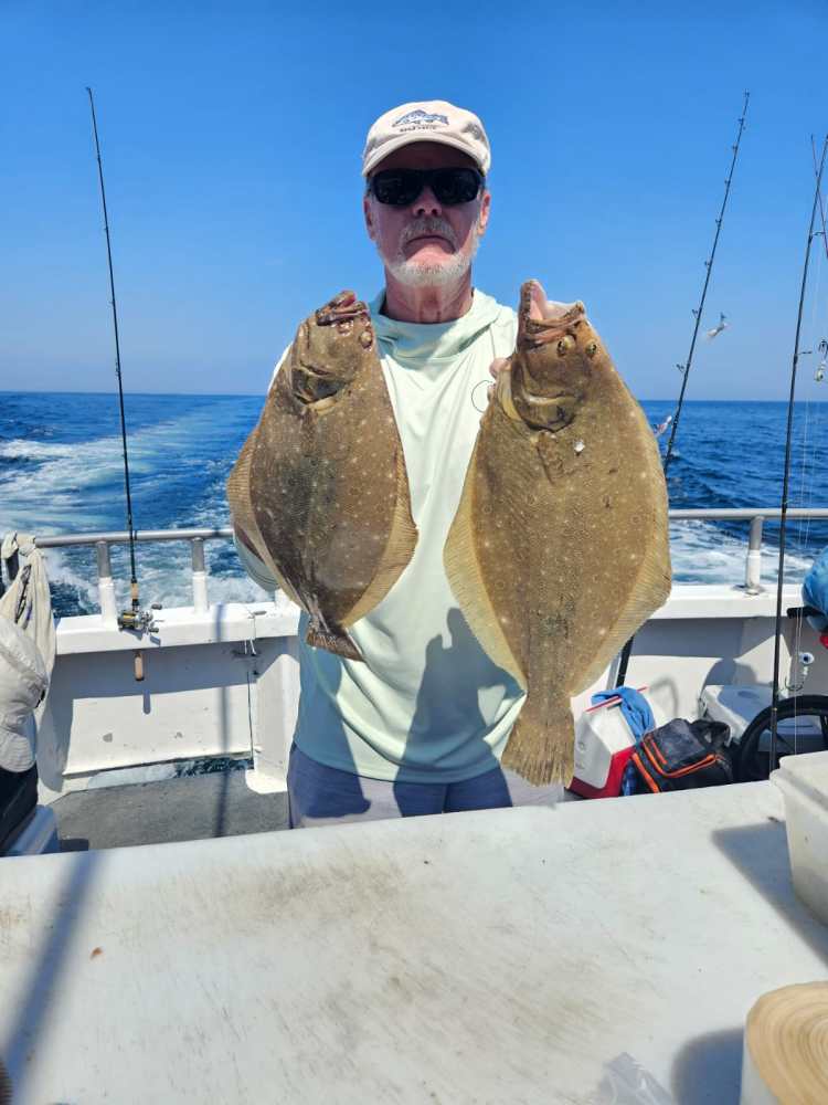 a man holding a fish on a boat