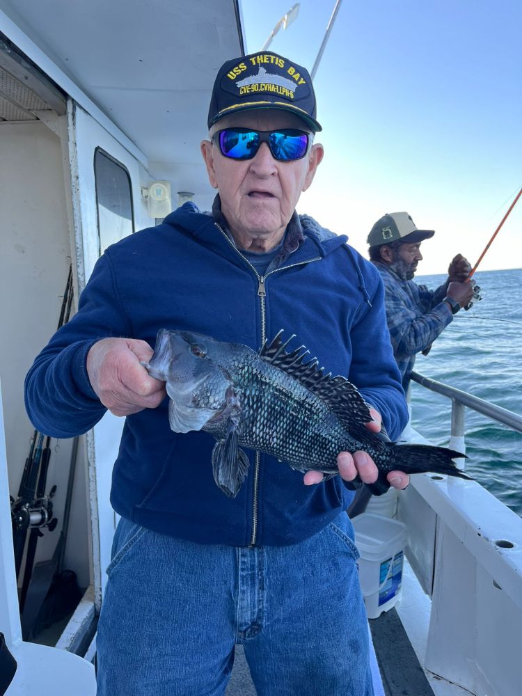 a man holding a fish on a boat