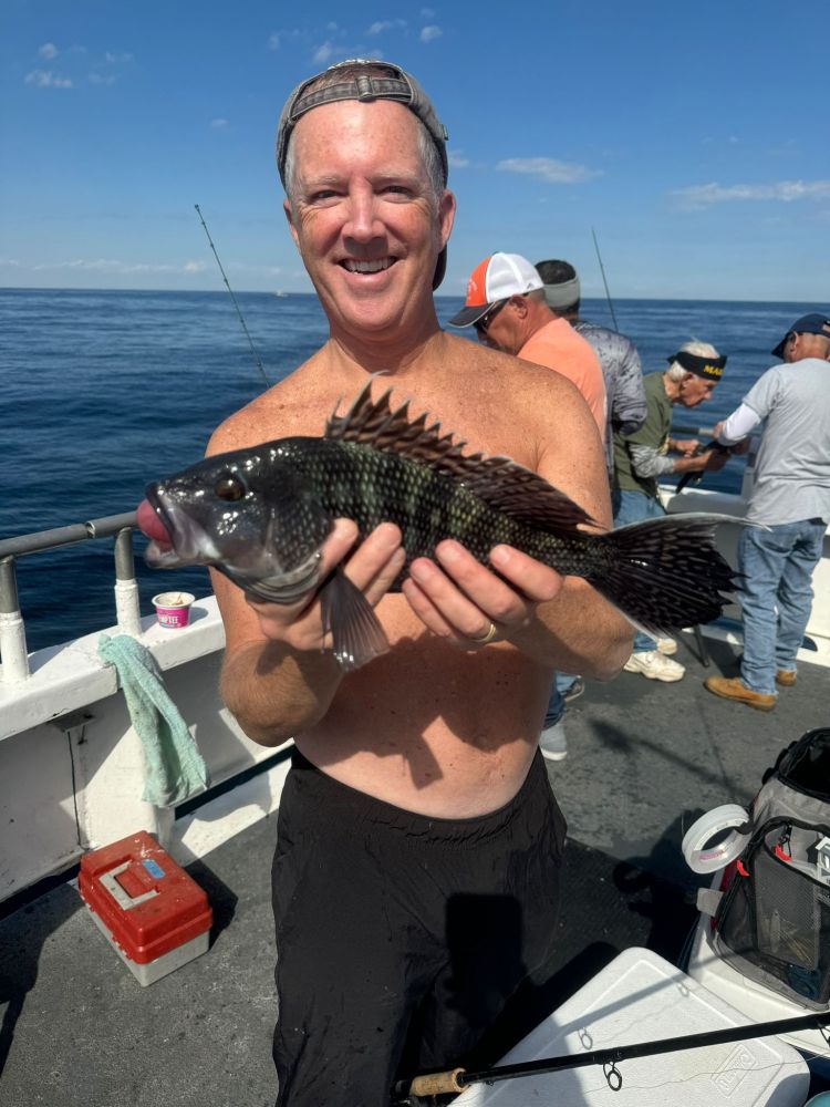 a man holding a fish on a boat